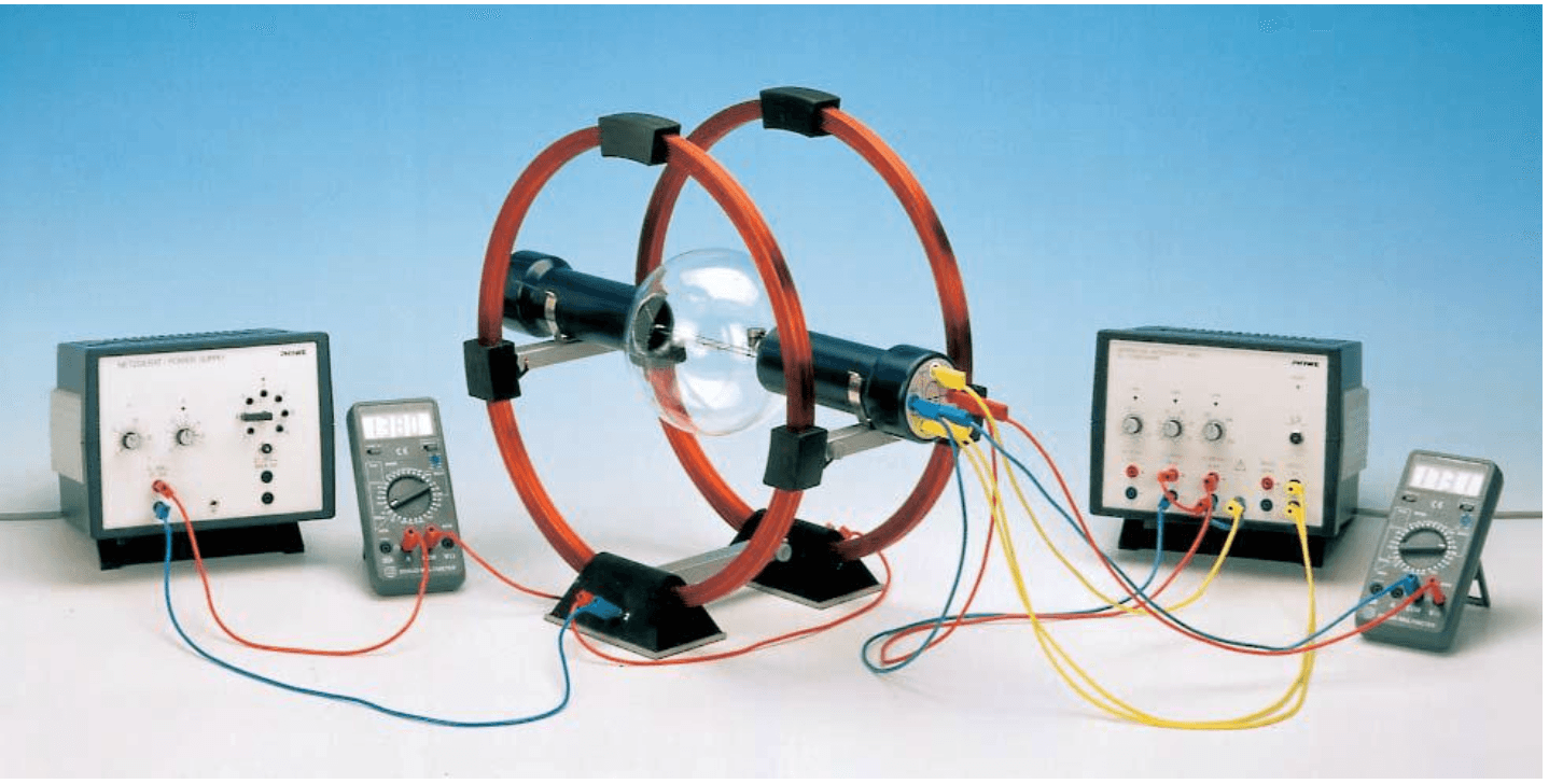 Helmholtz bobini ve dar demet tüpünden oluşan deney düzeneği. Ayrı DC güç kaynakları hızlandırma gerilimi ve bobin akımını sağlar.
